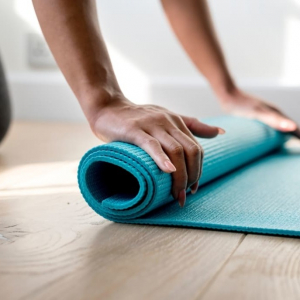 yoga-måtte Yogamåtte der bliver rullet sammen af en kvinde
